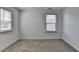Bedroom featuring two bright windows, neutral walls, and plush carpeting at 1659 Hay Patch Ln, Loganville, GA 30052
