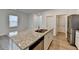 The island in this kitchen features granite countertops, stainless appliances, and sleek white cabinetry at 1659 Hay Patch Ln, Loganville, GA 30052
