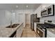 This kitchen offers a spacious island, stainless appliances, granite counters, and wood-look floors at 1659 Hay Patch Ln, Loganville, GA 30052