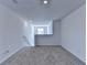 Bright living room with neutral walls and plush carpeting, with a pass-through window to another room at 1659 Hay Patch Ln, Loganville, GA 30052