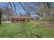 Expansive backyard with a brick home, patio area, and mature trees offering privacy at 2522 Brentwood Ct, Decatur, GA 30032