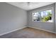 Small bedroom featuring gray walls, carpet flooring, and a window overlooking trees at 2522 Brentwood Ct, Decatur, GA 30032