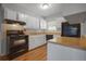 Traditional kitchen featuring white cabinets, laminate countertops, and black appliances at 2522 Brentwood Ct, Decatur, GA 30032
