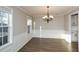 Formal dining room showcasing modern floors, wainscoting, and a chandelier for elegant dining at 3820 Mast Nw Ct, Kennesaw, GA 30144