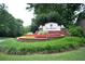 Entrance to Gramercy features lush landscaping, brick signage, and colorful flower beds at 3820 Mast Nw Ct, Kennesaw, GA 30144