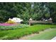 The Palisades entrance is marked by vibrant flowers, greenery, and brick pillars at 3820 Mast Nw Ct, Kennesaw, GA 30144