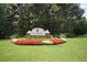 Lullwater entrance features colorful flower beds, manicured lawn, and lush trees at 3820 Mast Nw Ct, Kennesaw, GA 30144