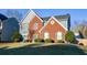 Traditional two-story home featuring brick and siding exterior, framed by a green lawn and mature trees at 3820 Mast Nw Ct, Kennesaw, GA 30144