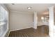 Open-concept room with hardwood floors, large window, and decorative columns at 3820 Mast Nw Ct, Kennesaw, GA 30144