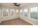 Bright sunroom featuring a ceiling fan and abundant natural light from numerous windows at 3820 Mast Nw Ct, Kennesaw, GA 30144