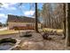 Spacious backyard featuring a stone-lined pond, deck, patio furniture, and mature trees at 4053 Thompson Mill Rd, Buford, GA 30519