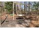 Charming wooden backyard swing set, nestled among mature trees, creates a relaxing retreat at 4053 Thompson Mill Rd, Buford, GA 30519
