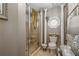 Well-decorated bathroom featuring a glass shower, decorative toilet, and an ornate window at 4053 Thompson Mill Rd, Buford, GA 30519