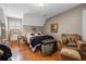 Cozy bedroom featuring hardwood floors, window with shutters, and a comfortable chair at 4053 Thompson Mill Rd, Buford, GA 30519