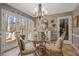 Elegant dining area with a round glass table, designer chairs, and access to an outdoor patio at 4053 Thompson Mill Rd, Buford, GA 30519