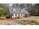 View of the house showing manicured yard with mature trees, a circular driveway, and a well-maintained lawn at 4053 Thompson Mill Rd, Buford, GA 30519