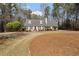 Attractive home featuring a manicured lawn with green bushes, black shutters, and a chimney at 4053 Thompson Mill Rd, Buford, GA 30519