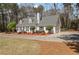 This home shows off a side-entry garage and mature manicured landscaping with circular driveway at 4053 Thompson Mill Rd, Buford, GA 30519