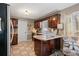 Kitchen with wooden cabinets, granite countertops, stainless steel refrigerator, and cozy breakfast bar at 4053 Thompson Mill Rd, Buford, GA 30519