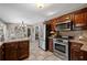 Modern kitchen with stainless steel appliances, dark wooden cabinets, and a view into the dining area at 4053 Thompson Mill Rd, Buford, GA 30519