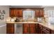 Close-up of a kitchen featuring dark wood cabinets, light granite countertops, and stainless steel appliances at 4053 Thompson Mill Rd, Buford, GA 30519