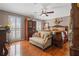 Cozy main bedroom with hardwood floors, plantation shutters, sitting area and a ceiling fan at 4053 Thompson Mill Rd, Buford, GA 30519