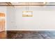 Minimalist living room featuring a modern chandelier, exposed concrete floor, and bright white walls at 878 Peachtree # 522, Atlanta, GA 30309