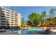 Outdoor pool with lounge chairs, lush greenery, and surrounding residential buildings at 878 Peachtree # 522, Atlanta, GA 30309