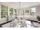Sunlit dining area showcases a glass table and modern chandelier with large windows for outdoor views and mirrored buffet at 1007 Belle Ave, Roswell, GA 30076