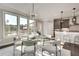 Bright dining area featuring a glass table and stylish chandelier, next to the kitchen with stainless appliances and bar seating at 1007 Belle Ave, Roswell, GA 30076