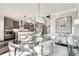 Open-concept dining area with modern chandelier, adjacent to the kitchen with stainless appliances, and access to staircase at 1007 Belle Ave, Roswell, GA 30076