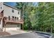 Rear exterior view featuring a deck over the garage and wooded surroundings at 1007 Belle Ave, Roswell, GA 30076
