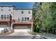 Townhome exterior featuring a deck above the garage in a wooded setting at 1007 Belle Ave, Roswell, GA 30076