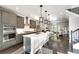 Open-concept kitchen with stainless appliances, white countertops, and a seamless transition to the living area and staircase at 1007 Belle Ave, Roswell, GA 30076