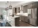 Spacious kitchen with stainless steel appliances, gray cabinets and a large island with quartz countertop and pendant lighting at 1007 Belle Ave, Roswell, GA 30076