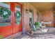Cozy front porch with seating, a vibrant door, and charming brick accents at 3123 Neal Ct, Cumming, GA 30041