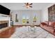 Cozy living room featuring a stone fireplace, hardwood floors, a comfortable seating arrangement, and a bright open space at 3123 Neal Ct, Cumming, GA 30041