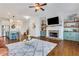 Open concept living room features a stone fireplace, custom shelving, and hardwood floors at 3123 Neal Ct, Cumming, GA 30041