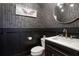Stylish powder room with dark wainscoting, marble countertop and golden accents at 3123 Neal Ct, Cumming, GA 30041