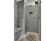 Contemporary tiled shower with built-in bench and pebble floor at 3123 Neal Ct, Cumming, GA 30041