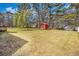 Large backyard featuring a lawn, mature trees, and storage sheds at 170 Double D Rd, Temple, GA 30179