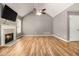 Spacious living room with hardwood floors, a vaulted ceiling, fireplace, and modern ceiling fan at 170 Double D Rd, Temple, GA 30179