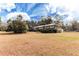 A ranch-style brick home with a large yard featuring mature trees and lush landscaping at 2443 Highway 92 S, Fayetteville, GA 30215