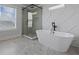 Luxurious bathroom features soaking tub, modern shower, patterned wall and large window at 4190 Hosch Reserve Dr, Buford, GA 30519