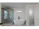 Bathroom featuring a standalone tub, glass-enclosed shower, and geometric accent wall at 4190 Hosch Reserve Dr, Buford, GA 30519