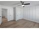 Bright bedroom featuring sleek ceiling fan, wainscoting and light hardwood flooring at 4190 Hosch Reserve Dr, Buford, GA 30519