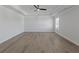 A spacious bedroom with wood floors, fan, tray ceiling, and natural light at 4190 Hosch Reserve Dr, Buford, GA 30519