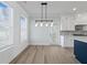 Bright dining room features large windows, shiplap walls, and stylish light fixture next to kitchen area at 4190 Hosch Reserve Dr, Buford, GA 30519