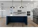 Bright kitchen boasts white cabinets, stainless steel appliances, blue island with quartz countertop, and modern pendant lighting at 4190 Hosch Reserve Dr, Buford, GA 30519