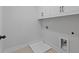 Clean and bright laundry room with white cabinets, tile floor and connections for a washer and dryer at 4190 Hosch Reserve Dr, Buford, GA 30519